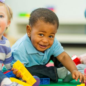 children sitting on floor playing with blocks