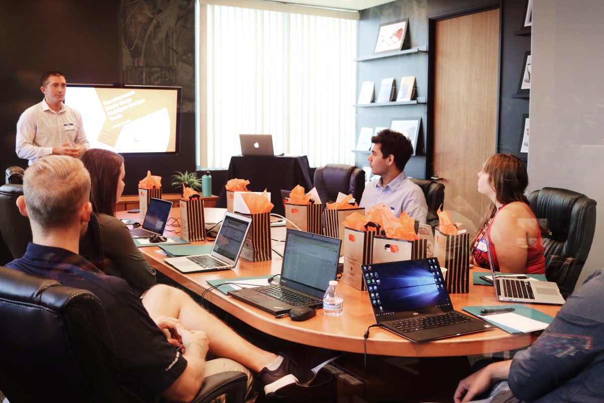 man standing in front of people at a conference room table