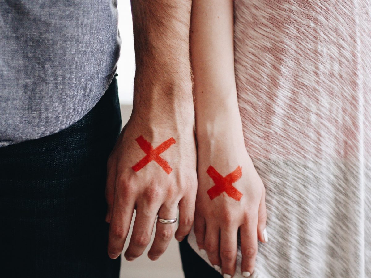 couples hands with red x