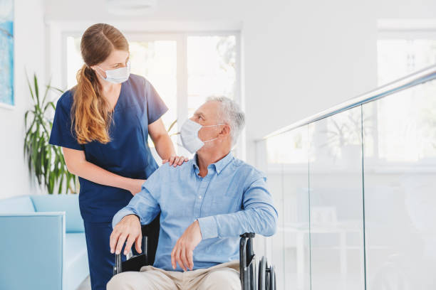 nurse with patient in wheel chair wearing mask