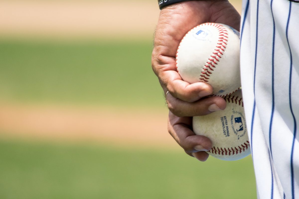 baseball player holding 2 baseballs