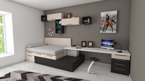 bed with desk and shelving on a gray wall