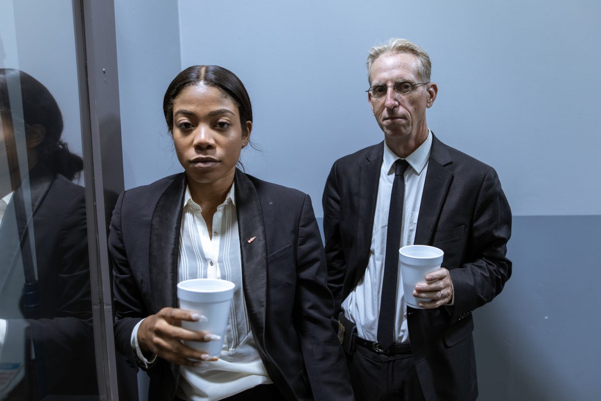 Man and woman in Black Suit Jackets Holidng a white coffee cup
