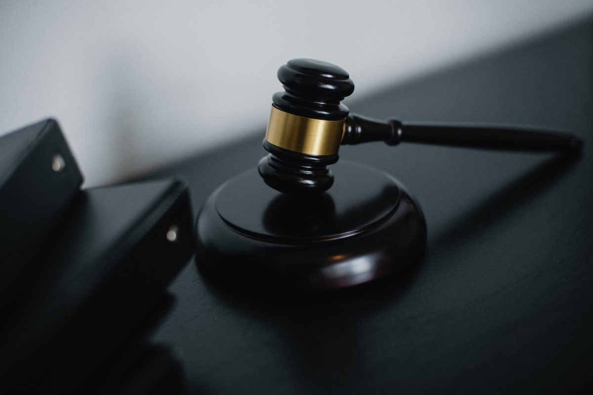 small judge gavel placed on table near folder
