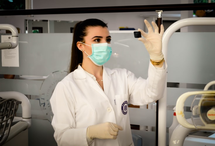 medical personnel looking at a block with mask on