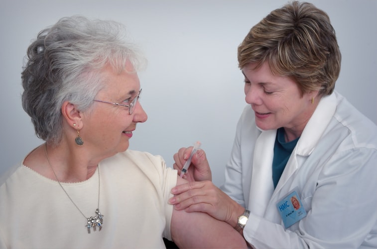nurse giving an elderly lady a shot in the arm