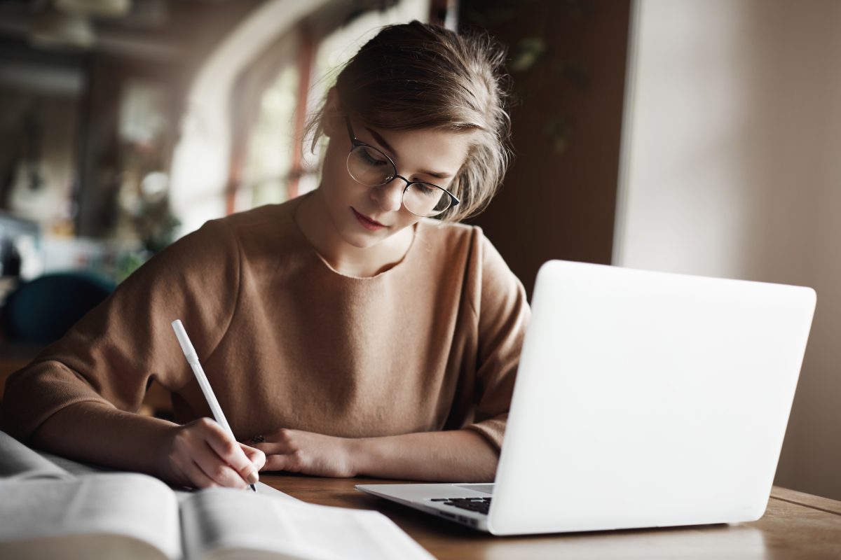 hardworking focused woman in trendy glasses writing 