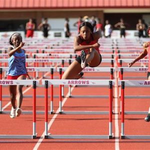Clinton High School Track Athlete Jumps Hurdle