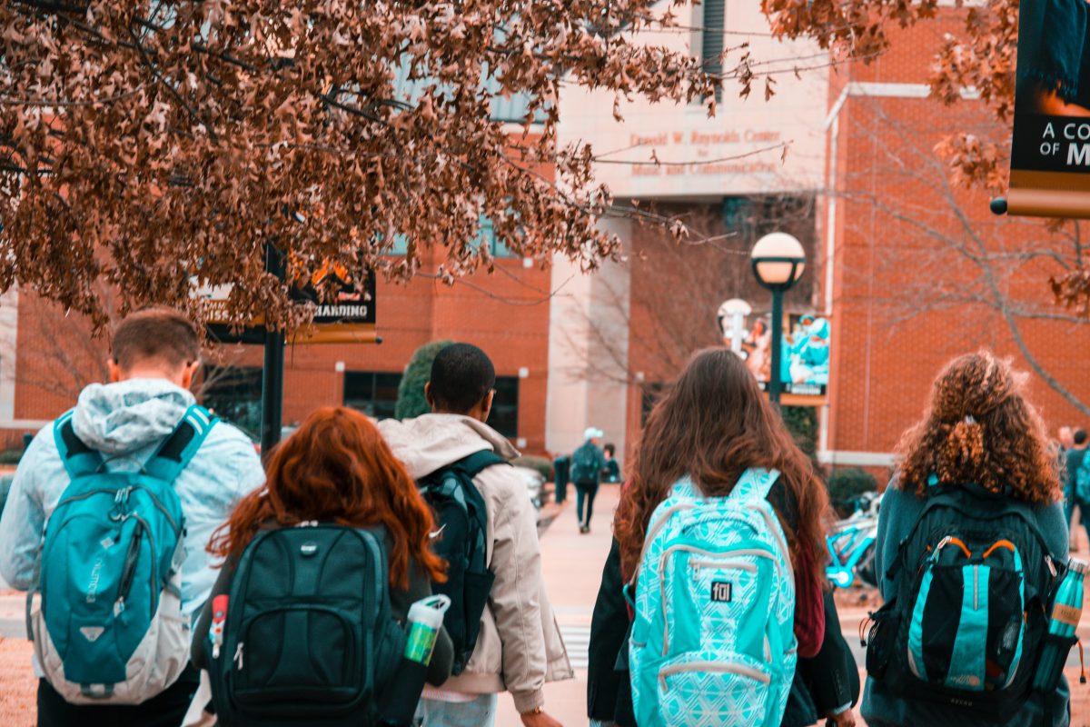students with backpacks walking to university