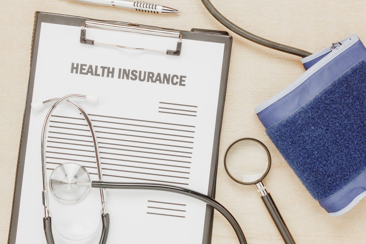<a href='https://www.freepik.com/photos/background'>Background photo created by osaba - www.freepik.com</a> view of health insurance form with pulse gauge