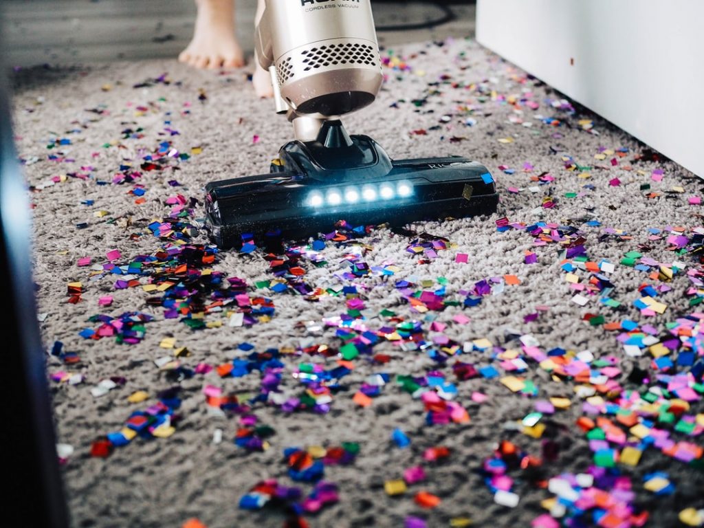 vacuum surrounded by confetti on the carpet