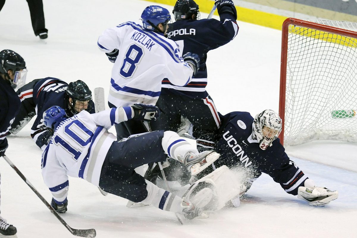 hockey players sliding at goal