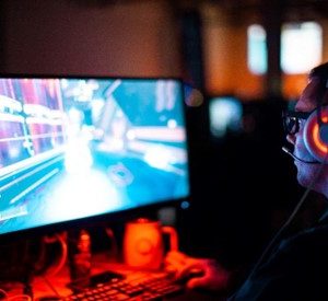 A person wearing headphones and sitting at a desk in front of a computer