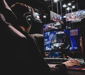 a boy wearing headphones and playing a game on the computer