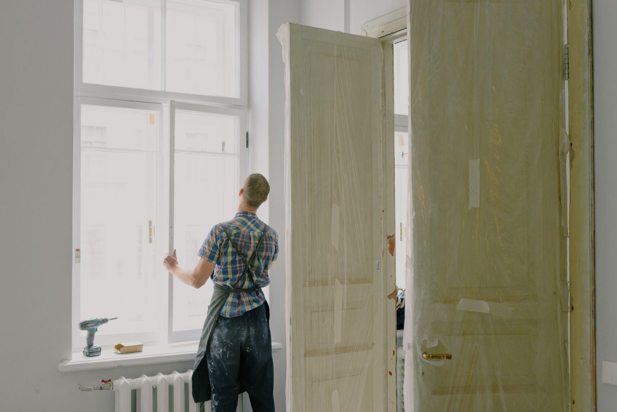faceless handyman installing window during home renovation
