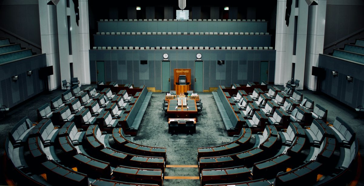 house of representatives meeting room with tables, chairs, and microphones