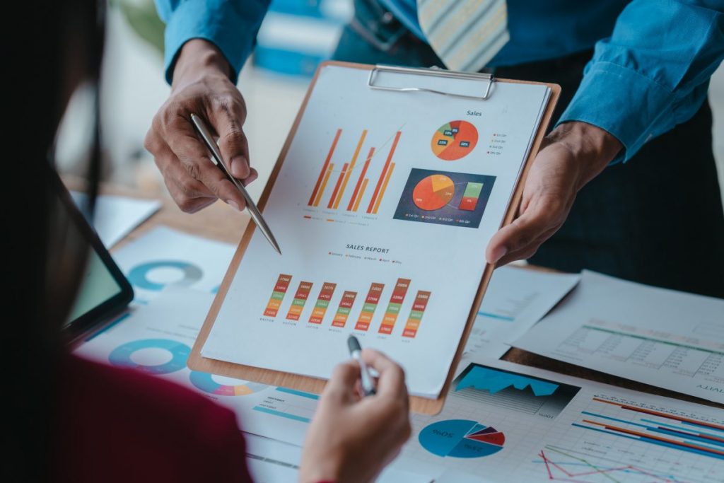 business man pointing to a graph on a sheet of paper