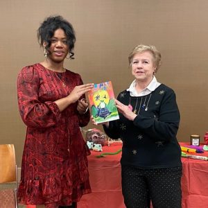 Diane Pleasant, known as Ms. P (right), presents her latest book, The Creepy Creek Chorus: A Lesson in Friendship to Brittany Moore (left), the Clinton library’s new branch manager.