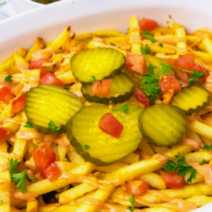 Cheeseburger and Fries in a dish are just as tasty without the bun when they're baked together and topped with basic burger toppings.