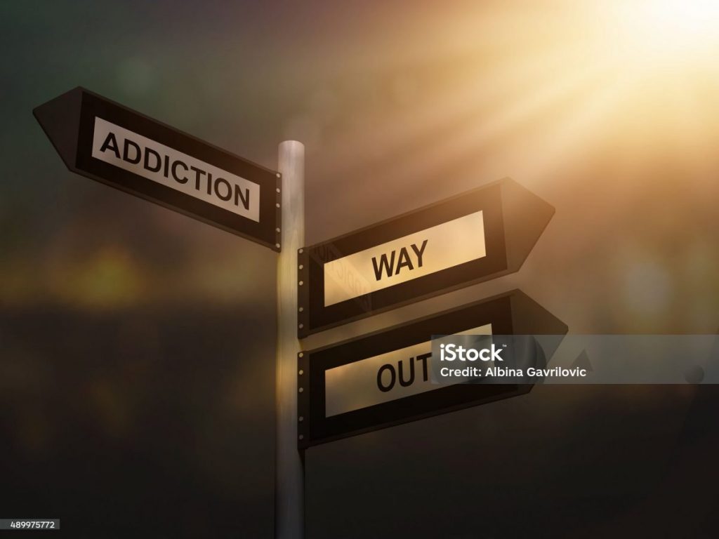 sign pointing to addiction and a way out