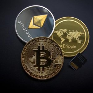 a group of coins (cryptocurriences) with a microchip on black background