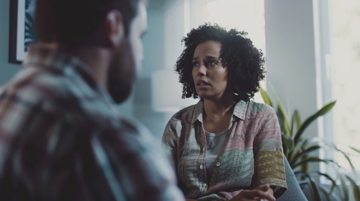 African American woman sitting in group couseling with worried look on her face