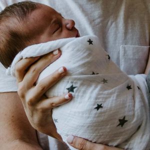 baby in swaddle being held