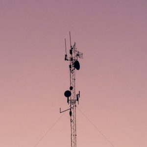 telecom towers with pink sky in background
