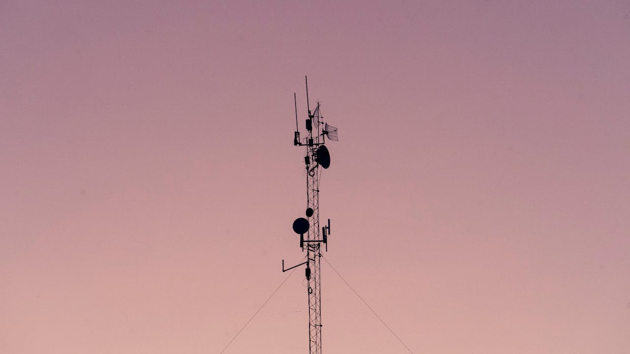 telecom towers with pink sky in background