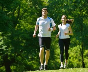 male and female runners running on grass