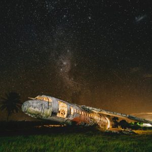 brightly lit destoryed plane under night sky