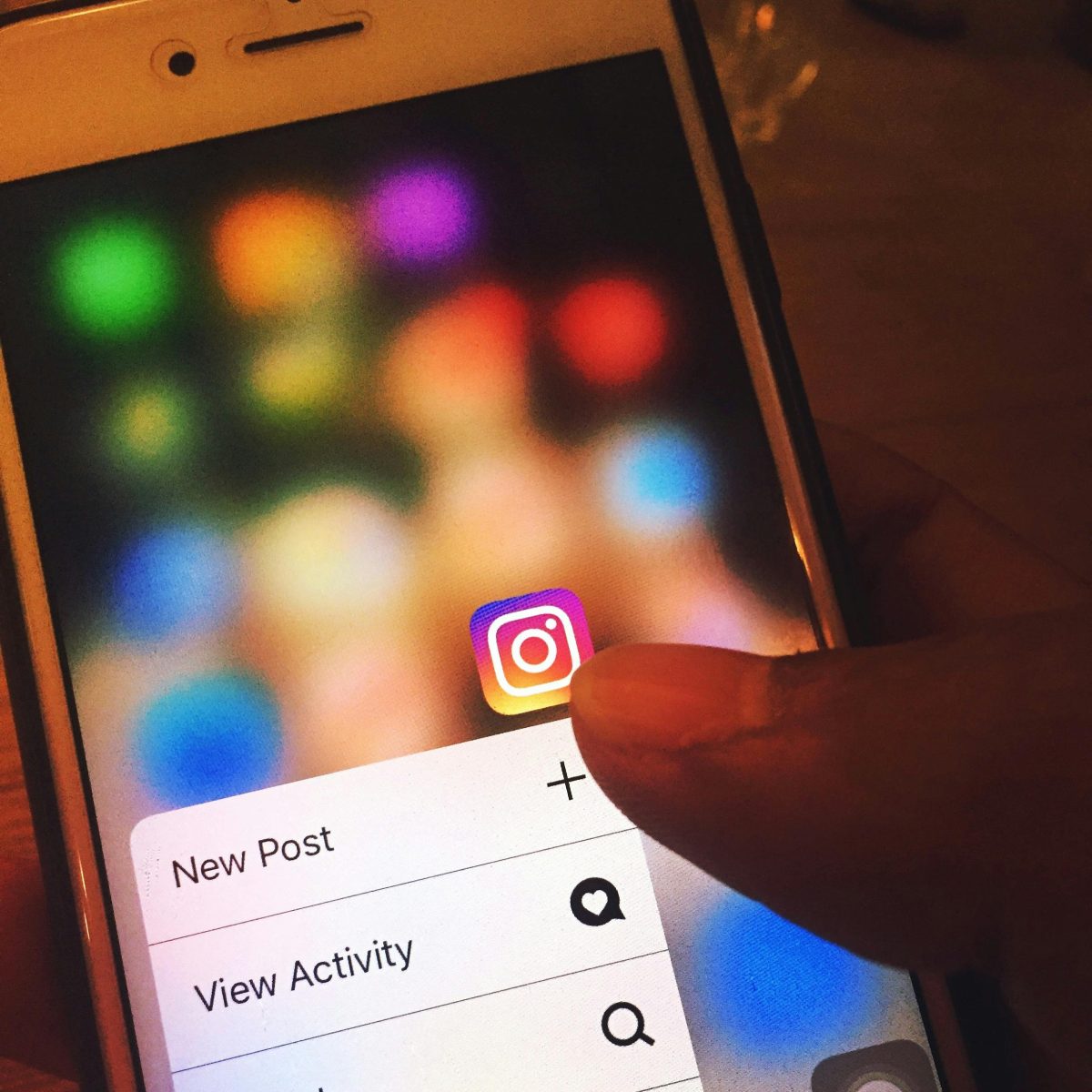 hand holding phone with instagram icon
