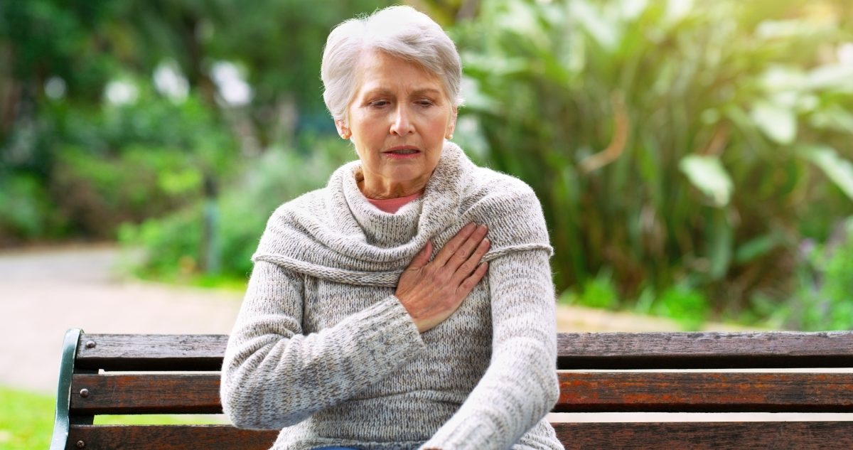 woman with hand on her chest in pain