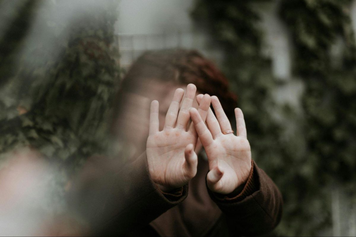 blurred photo with woman with hands in front of face
