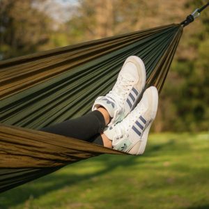 woman with addidas sneakers laying in hammock