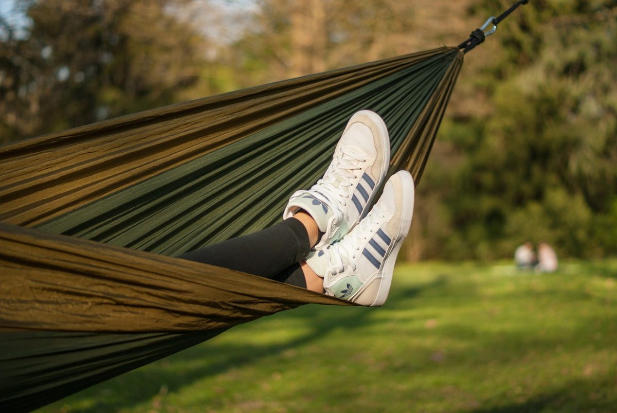 woman with addidas sneakers laying in hammock