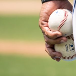 baseball player holding two baseballs in his left hand
