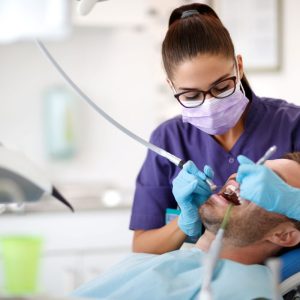 dentist working in gentleman's mouth