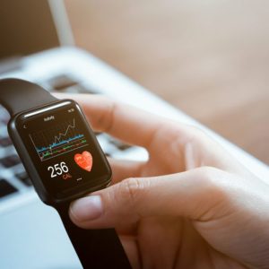 person holding a smart watch with heart on display