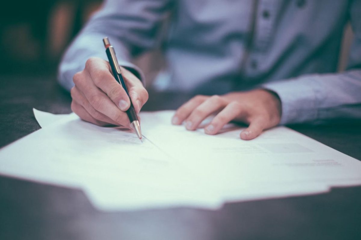 man in suit filling out paperwork 