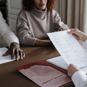couple sitting at a table with lady looking over paperwork