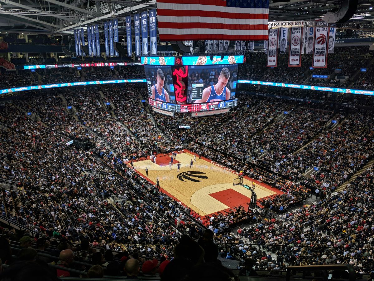 basketball stadium filled with people and a player on the jumbotron