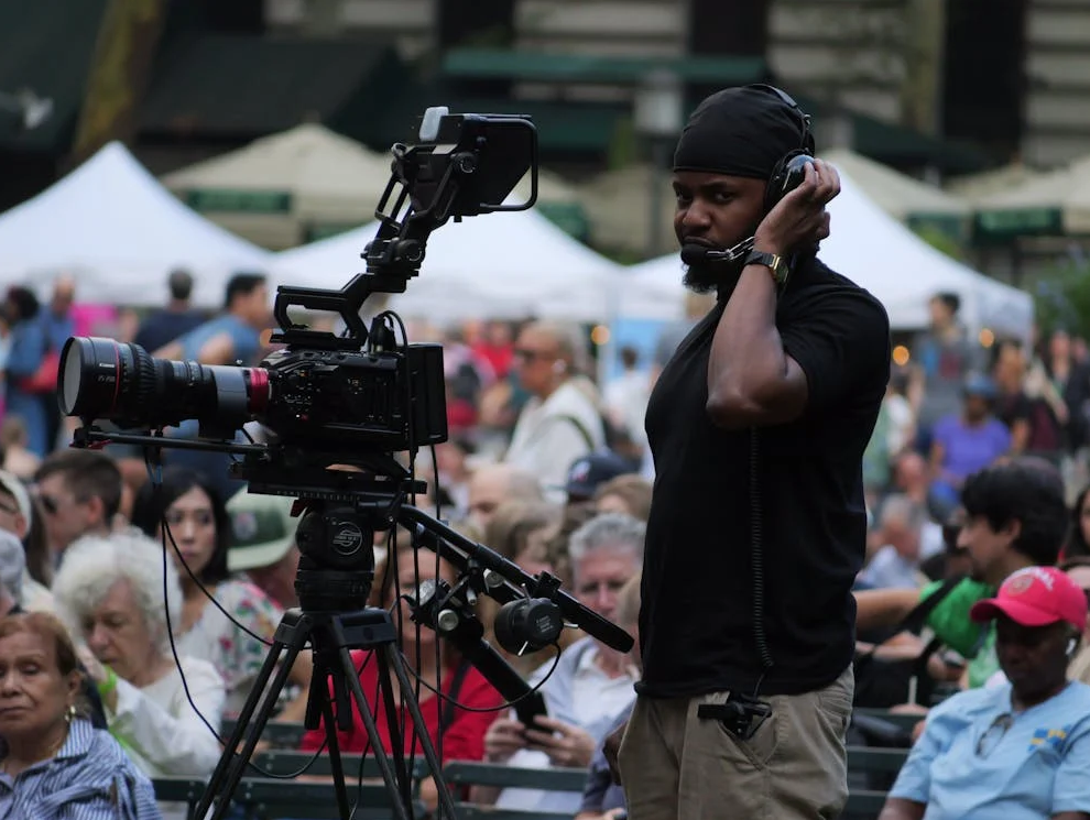 african american male with headphones on working a camera at a crowded event