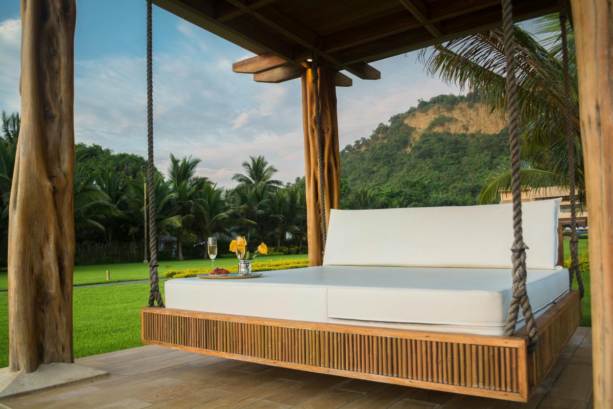 brown wooden outdoor swing bed with white mattress