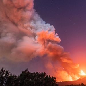 smoke filled sky with fire burning across the mountains