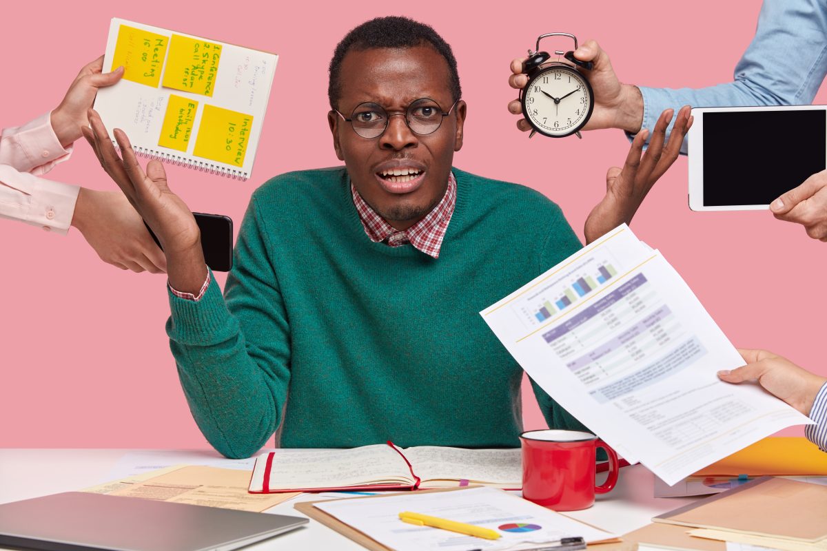 African American Male sitting at table looking overwhelmed