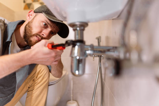 plumber workingo n pipes below a sink