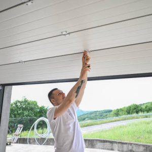 man repairing rolling garage door