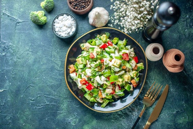 a plate of salad with fork and knife