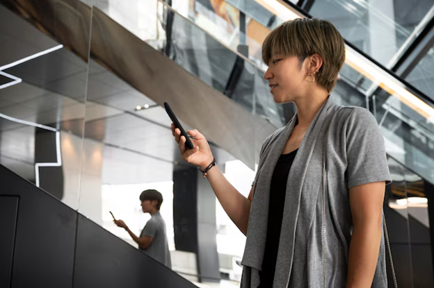 woman holding phone with reflection in the background